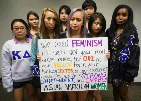 Eine Gruppe junger Frauen hält ein Plakat hoch: We need feminism because we are NOT your mail order brides, the CURE to your YELLOW fever, your fantasy SEX TOYS or your subservient housewives. We are STRONG, INDEPENDENT and CAPABLE ASIAN AMERICAN WOMEN